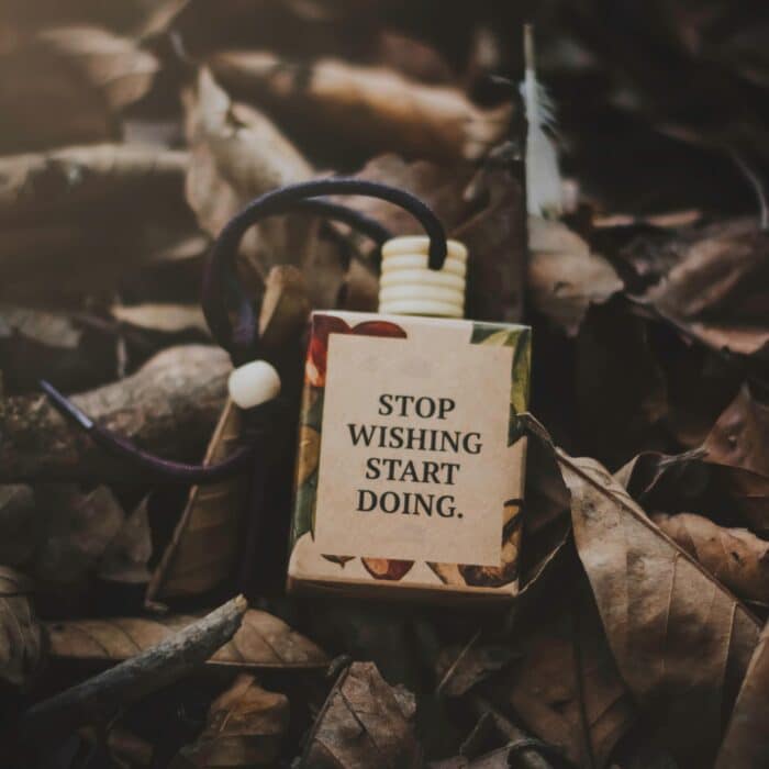 A box with a motivational quote amid dry autumn leaves, inspiring action.